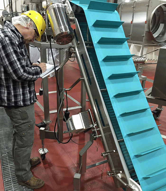Technician reviewing repair log for a conveyor